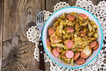 Sliced pork sausages with cabbage in ceramic bowl