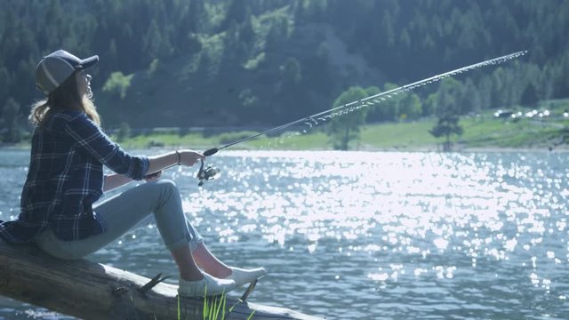 girl sitting on a log fishing