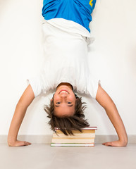 Kid with school books upside down education concept