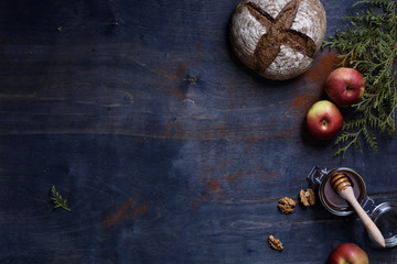 Farmers homemade bread with nuts, honey and apples over wooden background. Top view, copy space.