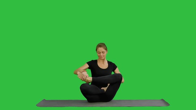 Sporty attractive woman practicing yoga, sitting in Full Lotus exercise, Siddhasana pose, working out on a Green Screen, Chroma Key