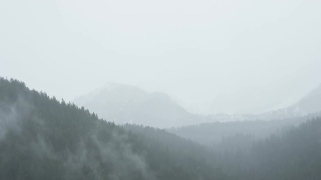 Clouds roll through foggy mountains