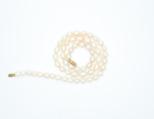 on a white background lies a pink pearl necklace on the neck