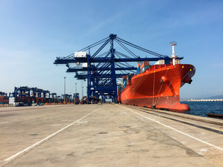 Cranes of dockers loading boat with containers in Algeciras port