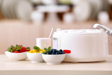Naklejka na ściany i meble Modern yogurt maker and ingredients on kitchen table