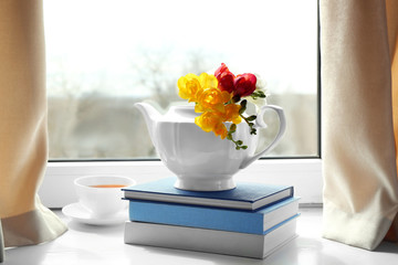 Composition with beautiful freesia flowers on window sill
