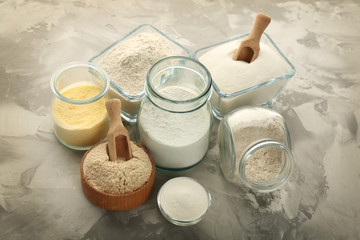 Composition with different types of flour on grey textured background