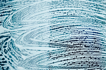 Fototapeta na wymiar Texture of soap foam on the surface of the glass.