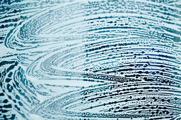 Texture of soap foam on the surface of the glass.