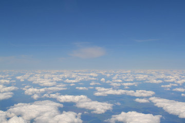 Traveling by air. View through an airplane window. Cirrus and cumulus clouds and little turbulence, showing Earth's atmosphere.