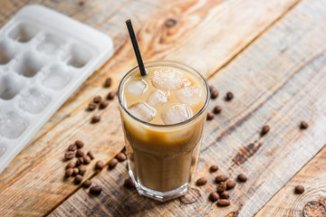 iced coffee with beans for cold summer drink on wooden background