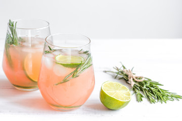 vegetable smoothie with lime and rosemary in glass on white table background