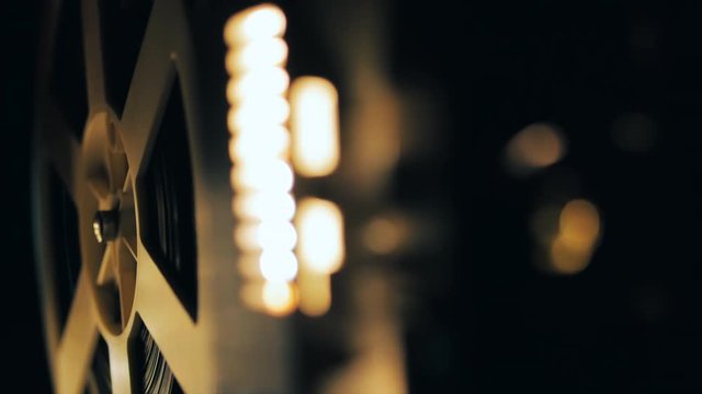 Old 8mm film projector playing in the night. Close-up of a reel with a film. 4k