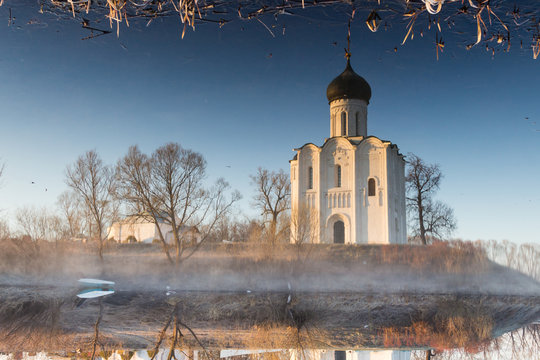 Magic reflection of a beautiful, ancient church in a pond, a frosty morning