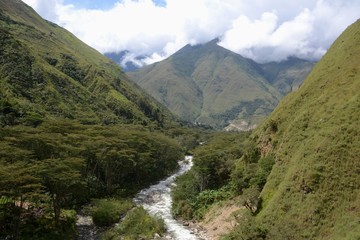 Fototapeta na wymiar Small river flowing down through a Picturesque valley in the Peruvian mountains.