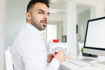 Young businessman working at office on computer desk