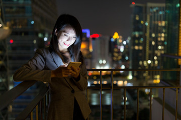 Business woman working on mobile phone at night