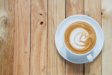 Top view of hot coffee latte art on wood table background