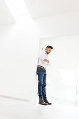 Attractive young man posing in white modern interior