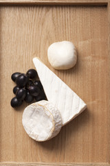 Cheese and grape on wooden background