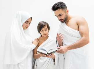 Muslim family posing as ready for Hajj visiting Kaaba in Mecca