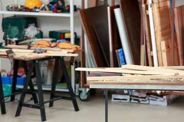 Table with wooden boards in carpenter's workshop