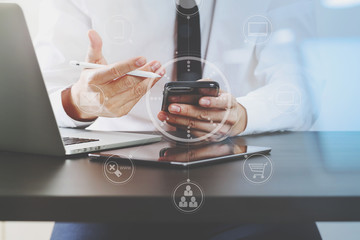 close up of businessman working with smart phone on wooden desk in modern office with virtual icon diagram