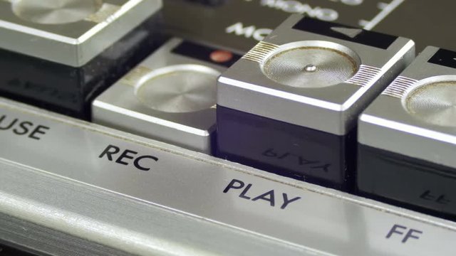 Pushing Record Button on a Vintage Tape Recorder. Close-up. Pushing a Finger Button Record. Man finger presses playback control buttons on audio cassette player.