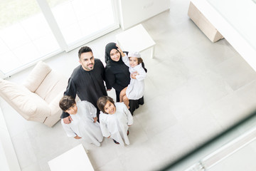 High angle view portrait of happy Arabic Muslim family at new modern home