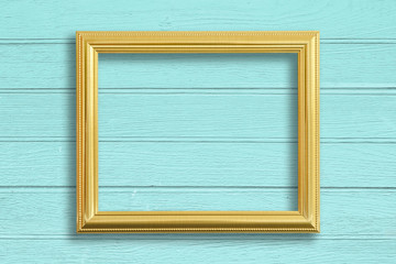 Gold picture frame on vintage wood wall.