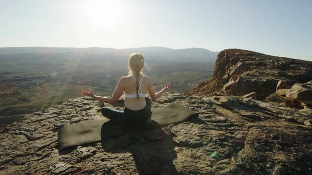 medium shot of woman doing yoga in the desert