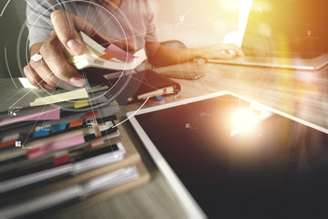 businessman working with mobile phone and digital tablet and laptop computer on wooden desk in modern office with virtual icon diagram