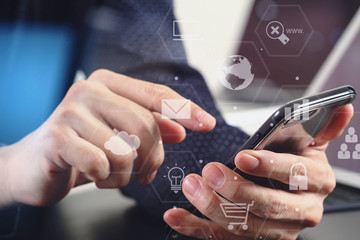 close up of businessman hand working with mobile phone and laptop and digital tablet computer in modern office