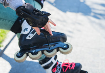 Fototapeta na wymiar Roller girl unscrewing wheels on freeskate roller Skates with Allen key or Hex key tool. Maintenance of professional skates