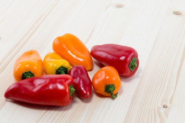 Different colors of bell pepper on a pine wood table board