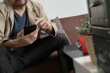 hipster hand using smart phone,digital tablet docking keyboard,coffee cup, payments online business,sitting on sofa in living room,work at home concept