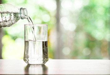  pouring purified fresh drink water from the bottle on table in living room