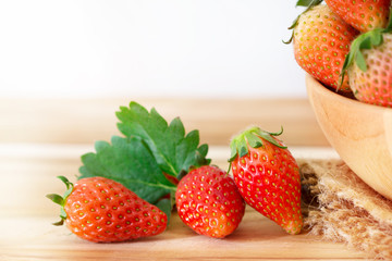 Red Strawberries and leaf on wooden table