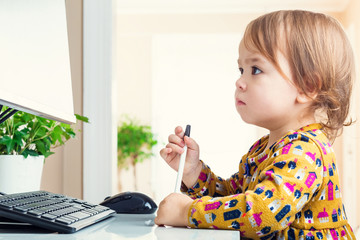 Toddler looking seriously at her computer screen