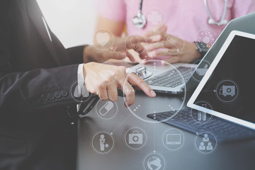 Medical co working concept,Doctor working with smart phone and digital tablet and laptop computer to meeting his team in modern office at hospital with virtual icon diagram