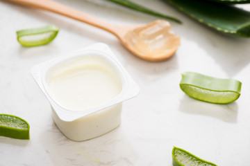 Aloe vera yogurt with fresh leaves on a wooden table