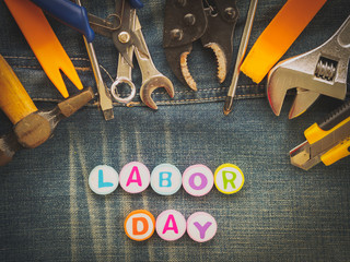 Labor day background concept - Jeans, many handy tools with labor day text on Jeans background top view