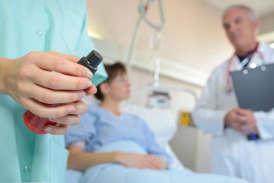 dr speaking with patient while nurse prepares medicine