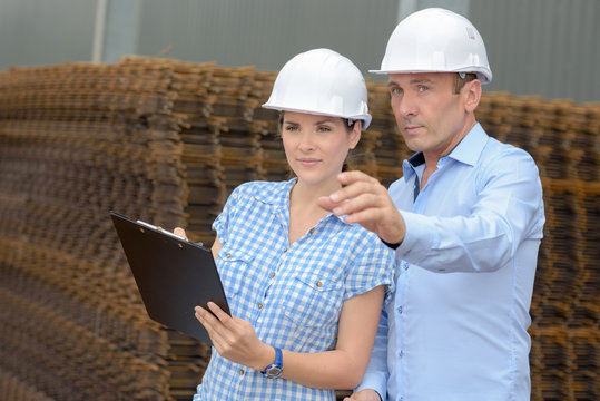 Man and woman next to pile of rebars