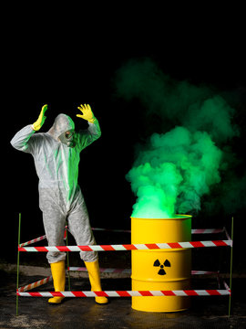 biohazard worker and radioactive green smoke coming out from yellow barrel