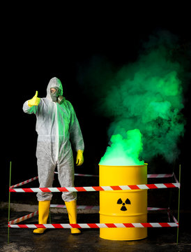 biohazard worker and radioactive green smoke coming out from yellow barrel