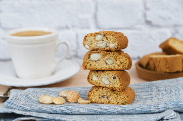 Close up of homemade biscotti cantuccini or cantucci, Italian almond sweets biscuits (cookies)  served with cup of coffee on wooden background.