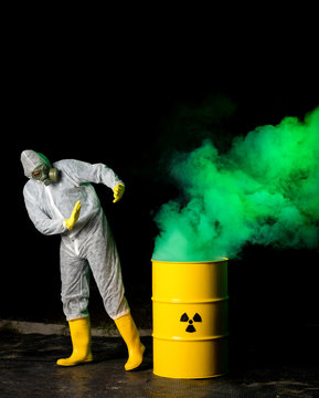 biohazard worker and radioactive green smoke coming out from yellow barrel