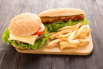 Hot dogs, hamburgers and french fries on the wooden background