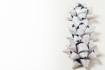 Silver holiday bows on white background
